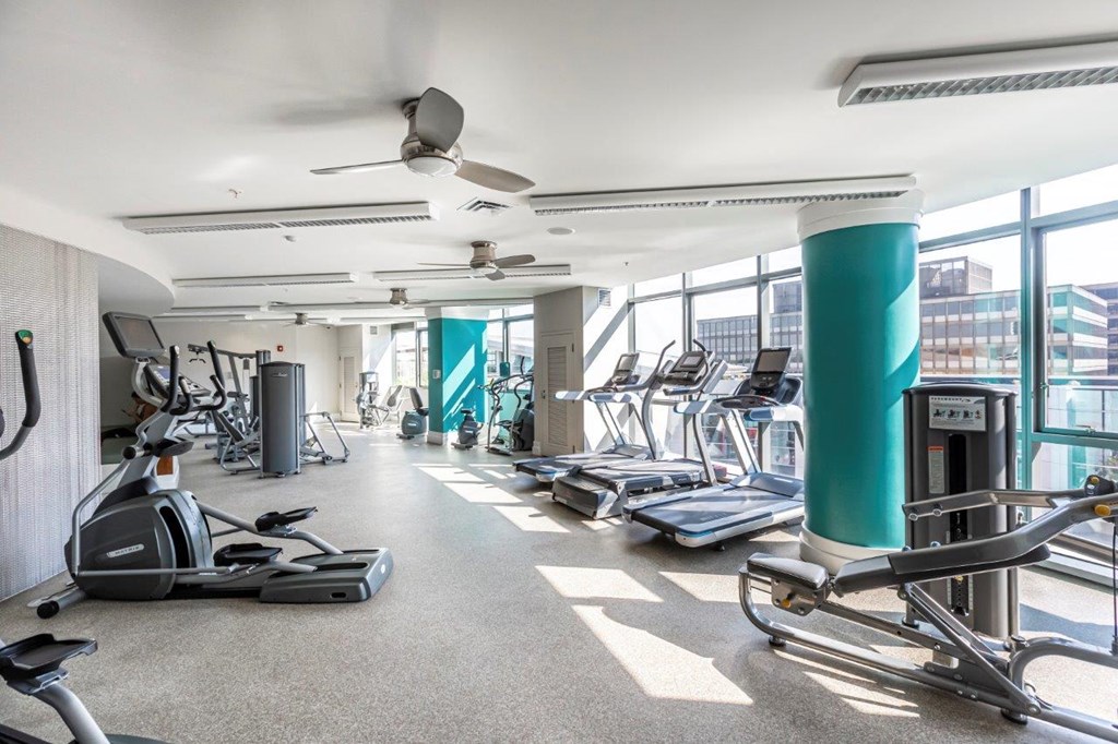 A gym with treadmills, elliptical machines, and other exercise equipment.