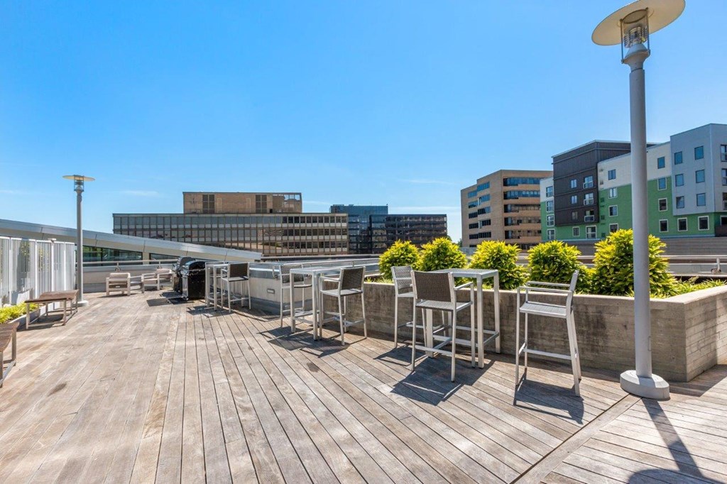 A wooden deck with chairs and a lamp post.
