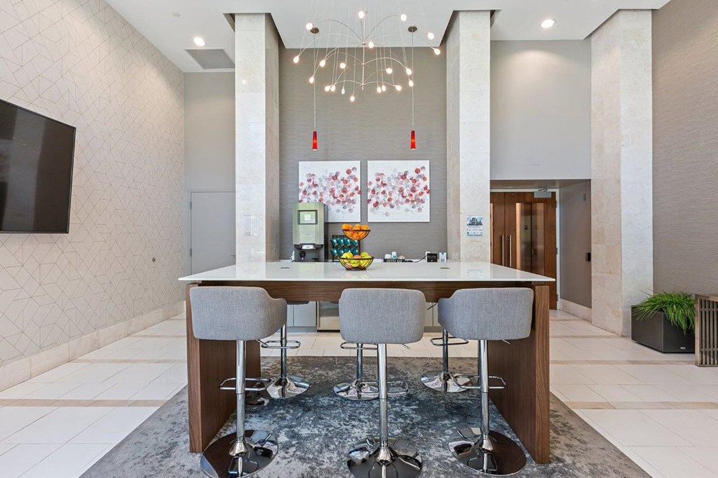 A modern dining area with a long table and grey chairs.
