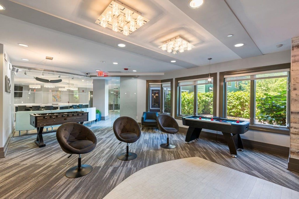 A room with a pool table and a foosball table.