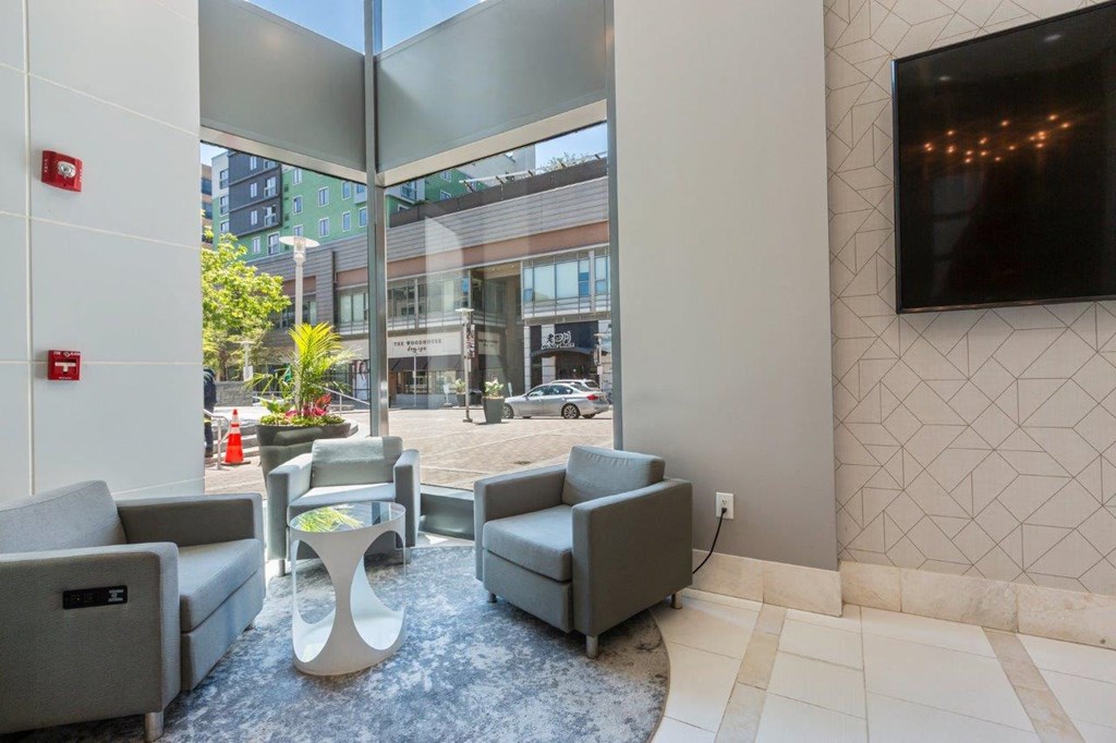 A modern waiting area with grey couches and a white coffee table.