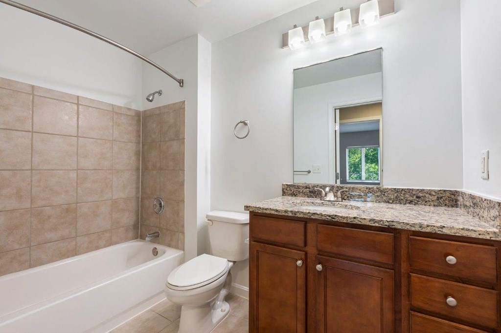 A bathroom with a toilet, sink, and tub.