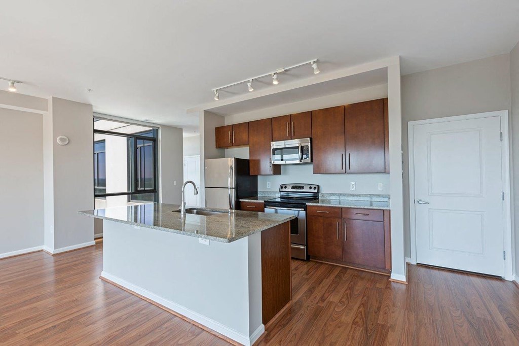 A kitchen with wooden cabinets and a white island.