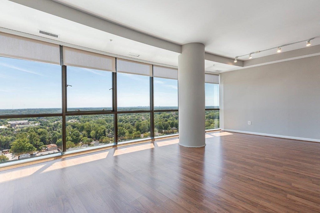 A room with a large window overlooking a cityscape.