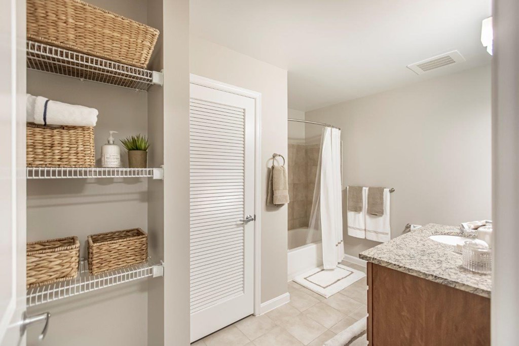 A bathroom with a white door, a white sink, and a white counter.