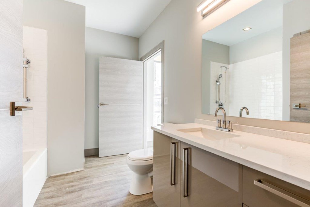 A white bathroom with a toilet, sink, and shower.