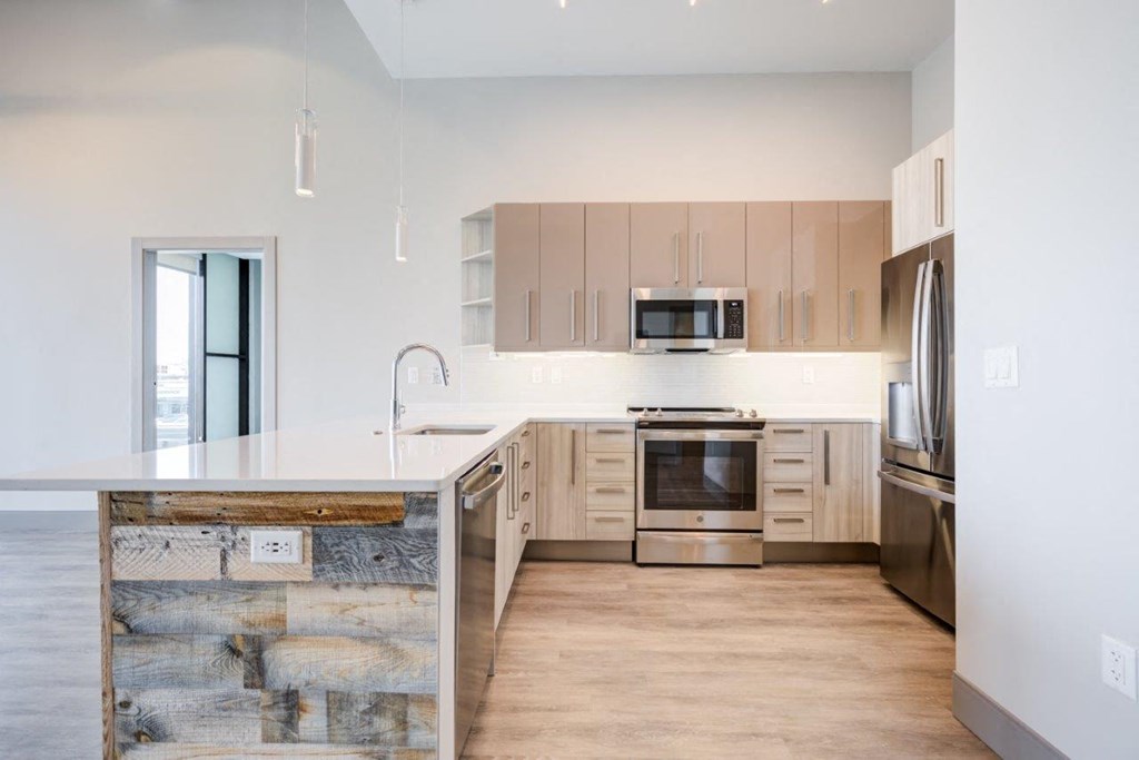 A modern kitchen with wooden cabinets and stainless steel appliances.