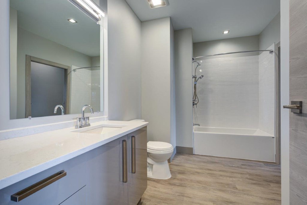 A white bathroom with a toilet, sink, and bathtub.