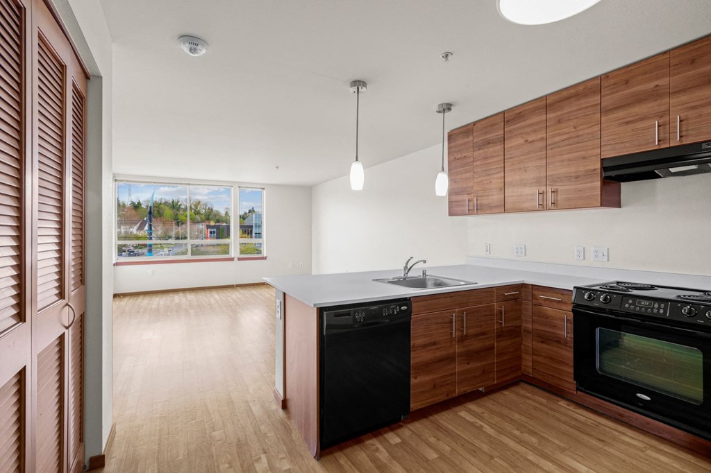 a kitchen with wooden cabinets and a black dishwasher
