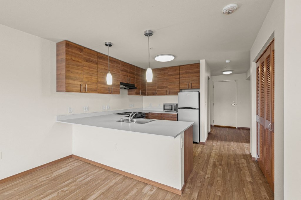 a kitchen with white countertops and wooden cabinets