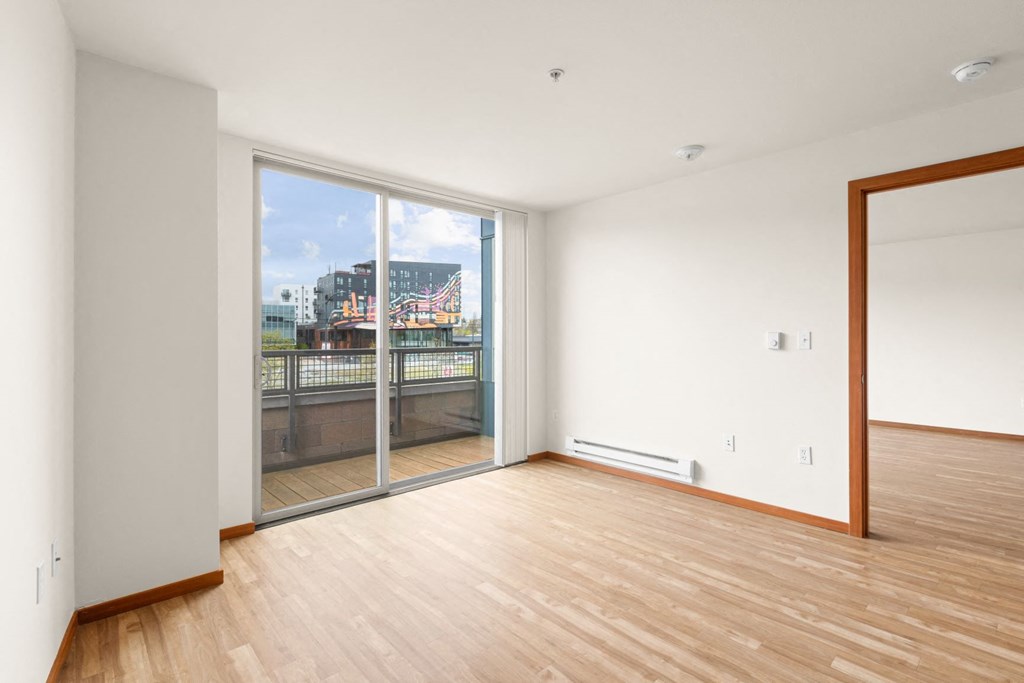 a bedroom with a large window and hardwood floors