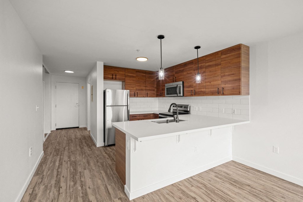 a kitchen with white countertops and wooden cabinets