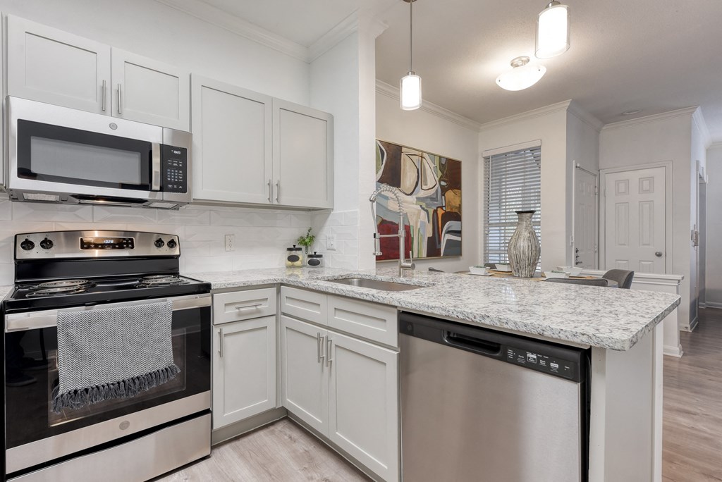 a kitchen with white cabinets and a granite counter top