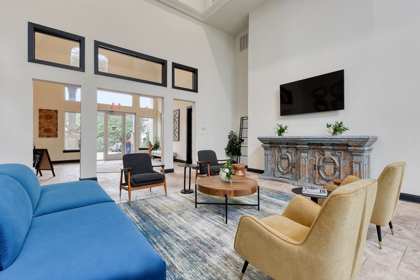 a living room with a blue couch chairs and a fireplace - Photo Gallery