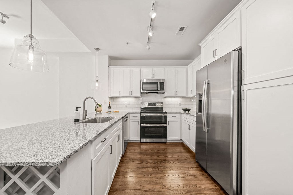 a kitchen with white cabinets and stainless steel appliances