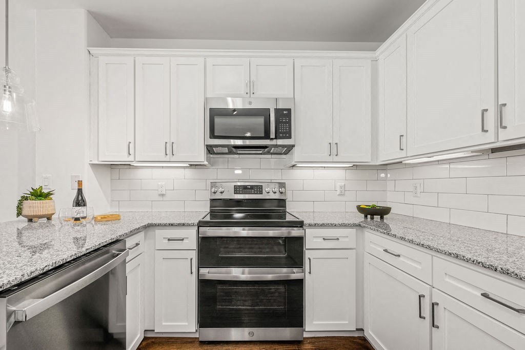 a kitchen with white cabinets and stainless steel appliances