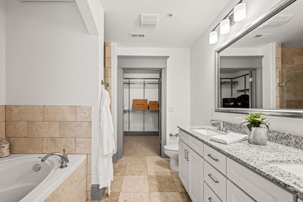 a bathroom with a tub and a sink and a mirror