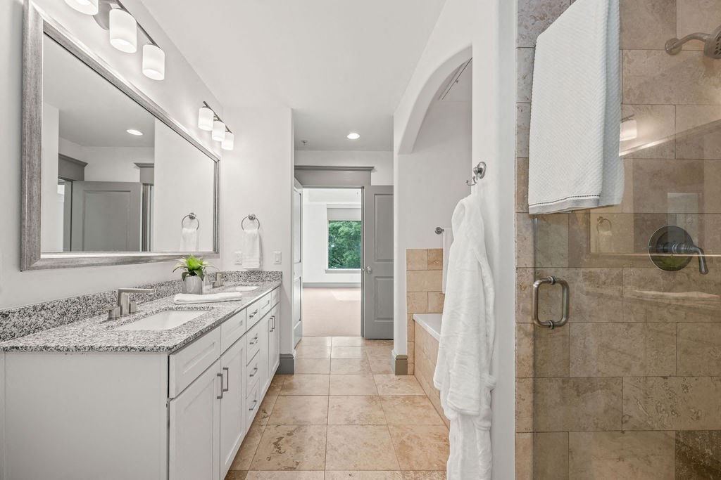 a bathroom with a sink and a shower and a mirror