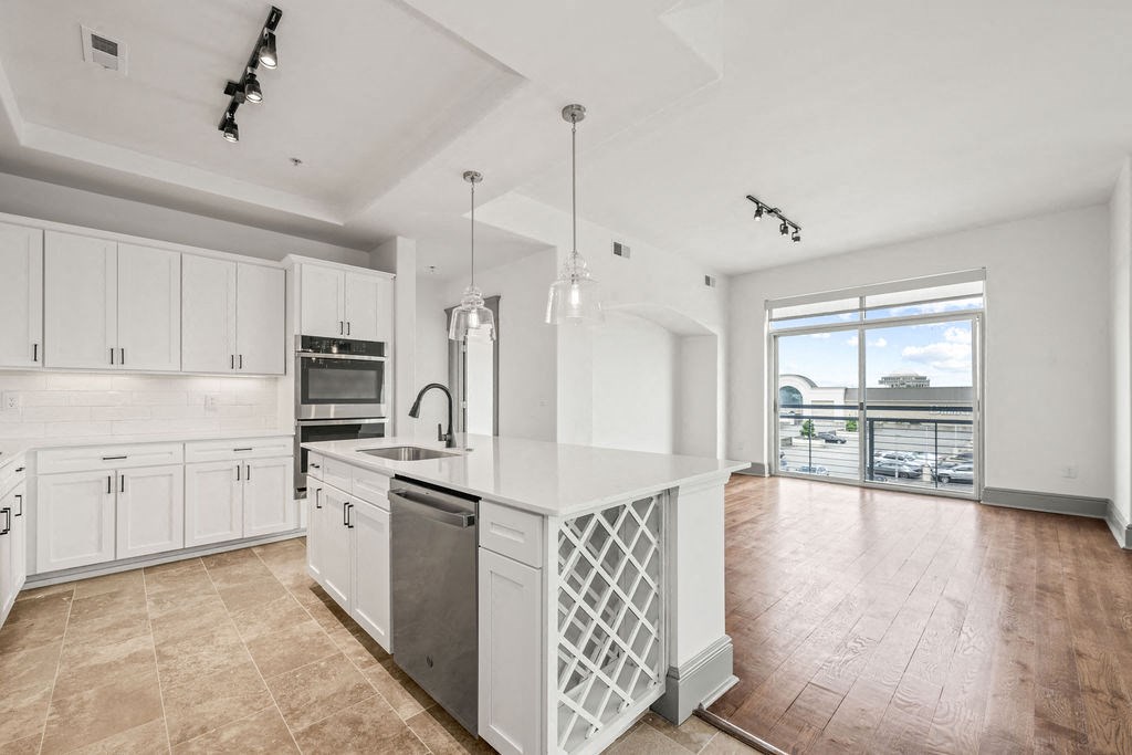 a white kitchen with a large island and a window