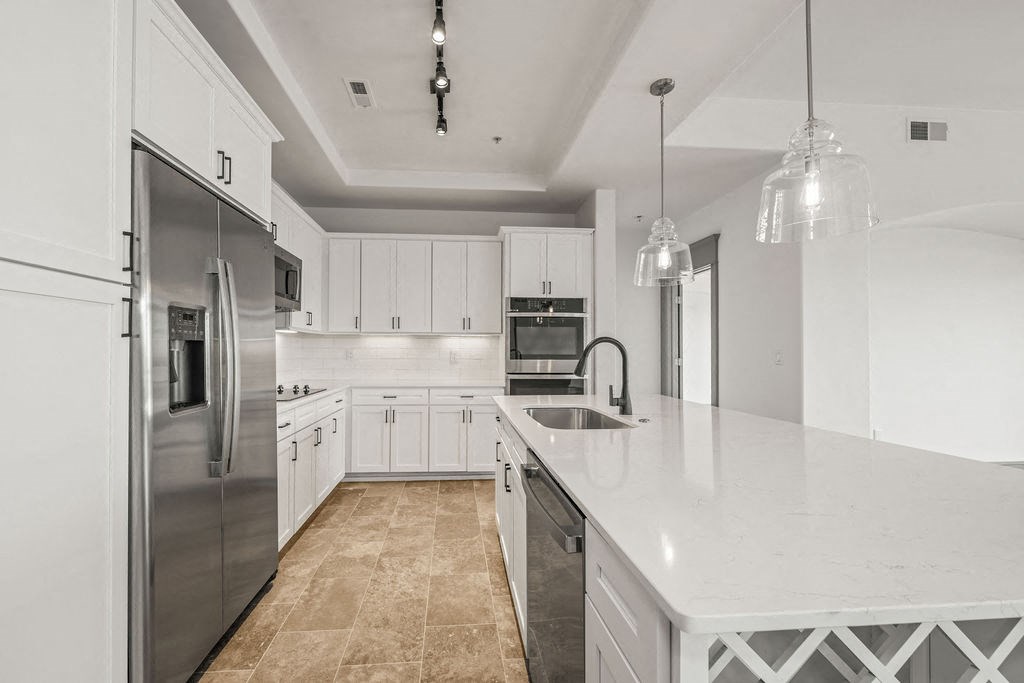 a large white kitchen with stainless steel appliances