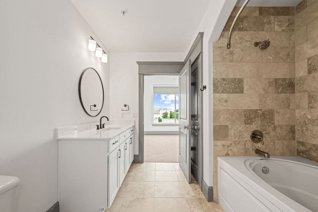 a bathroom with a tub and a sink and a mirror