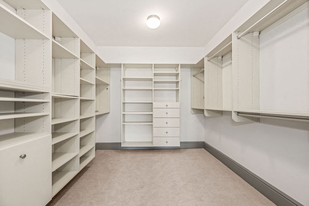 a large walk in closet with shelves and drawers