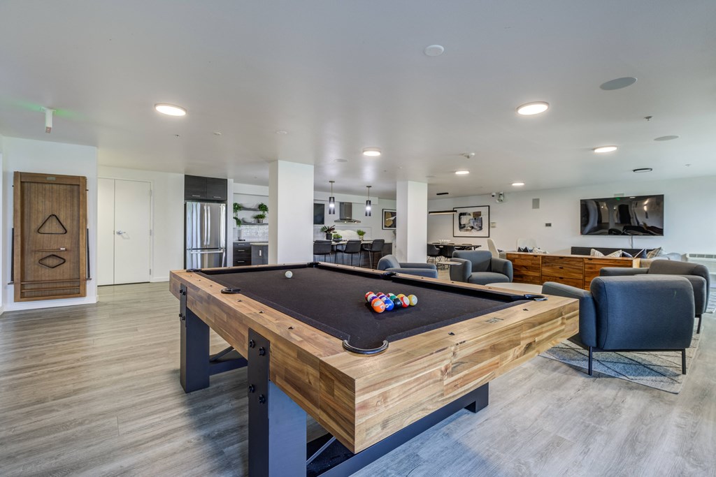 a pool table in a clubhouse with a tv in a living room