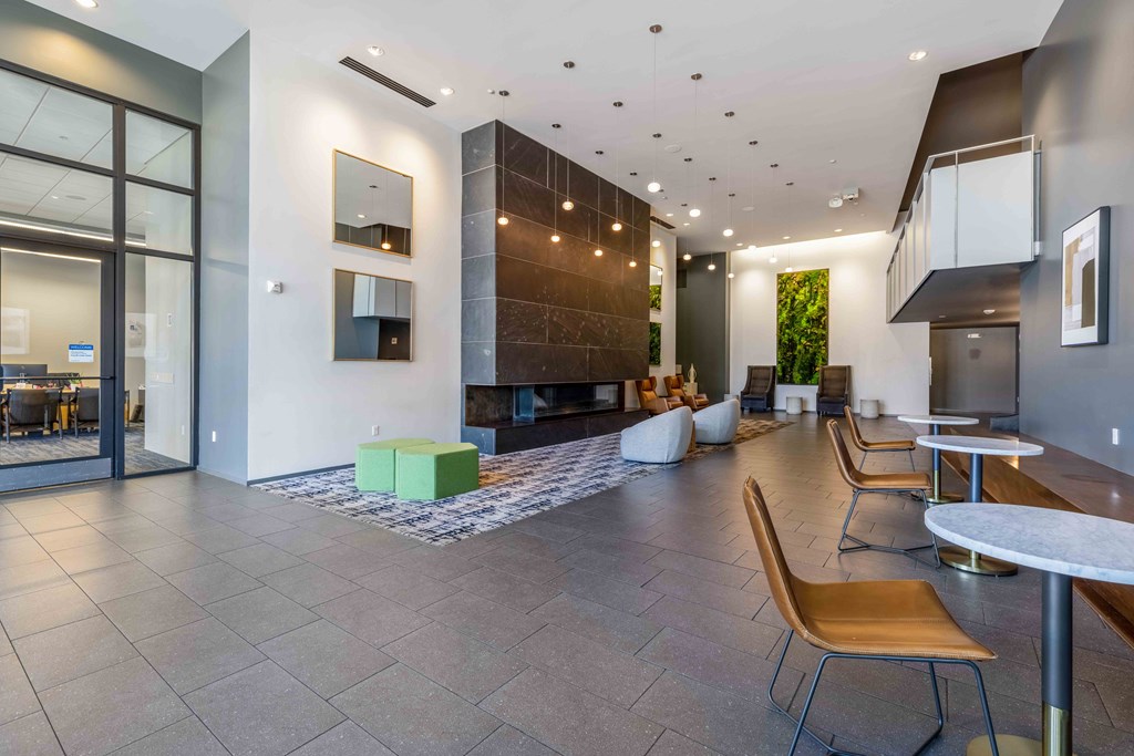 a lobby with tables and chairs and a fireplace