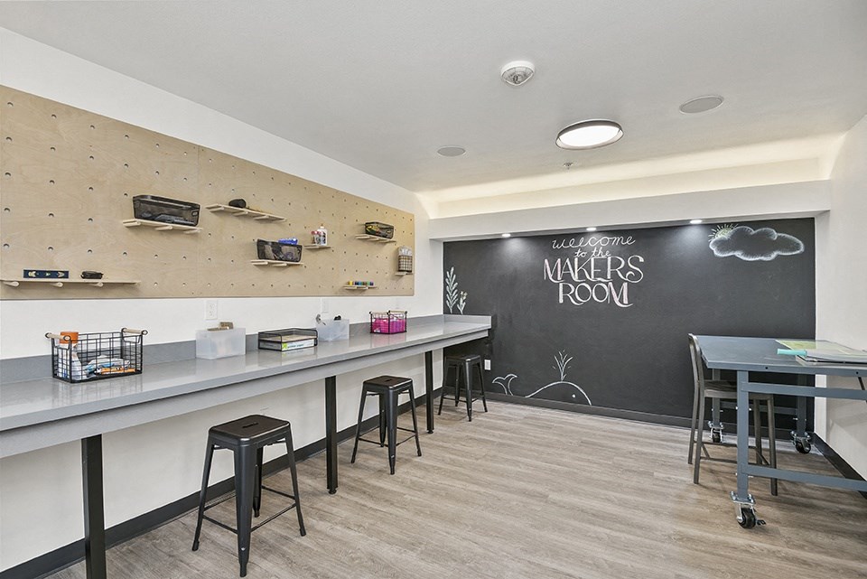a room with a chalkboard wall and a long table with stools