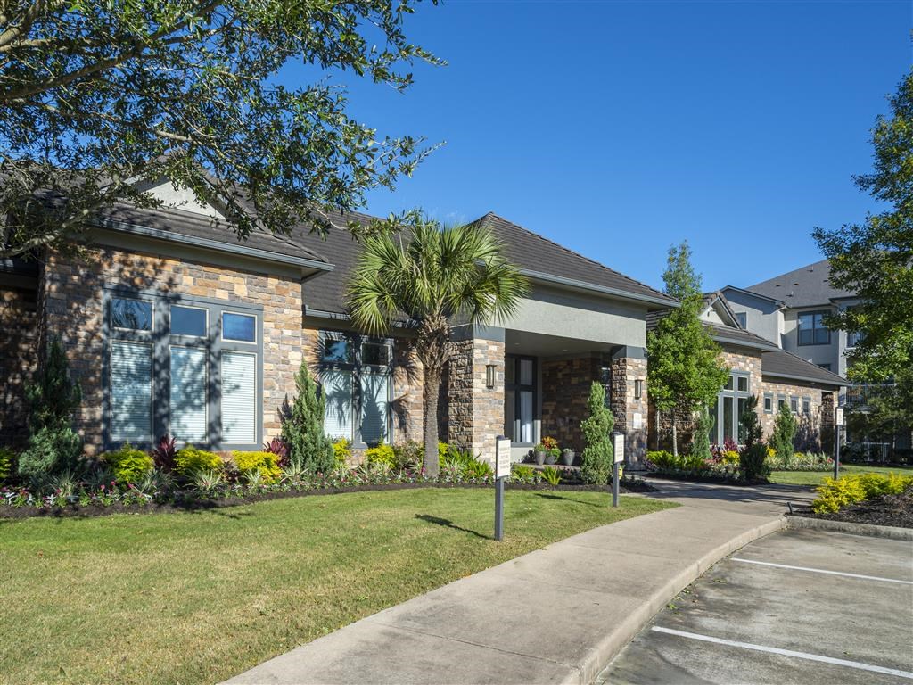 a sidewalk in front of a house with palm trees