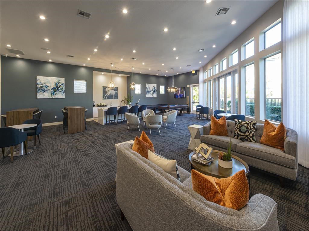 a lobby with couches chairs and tables and windows