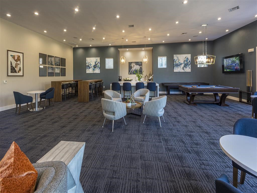 a clubhouse with tables and chairs and a pool table
