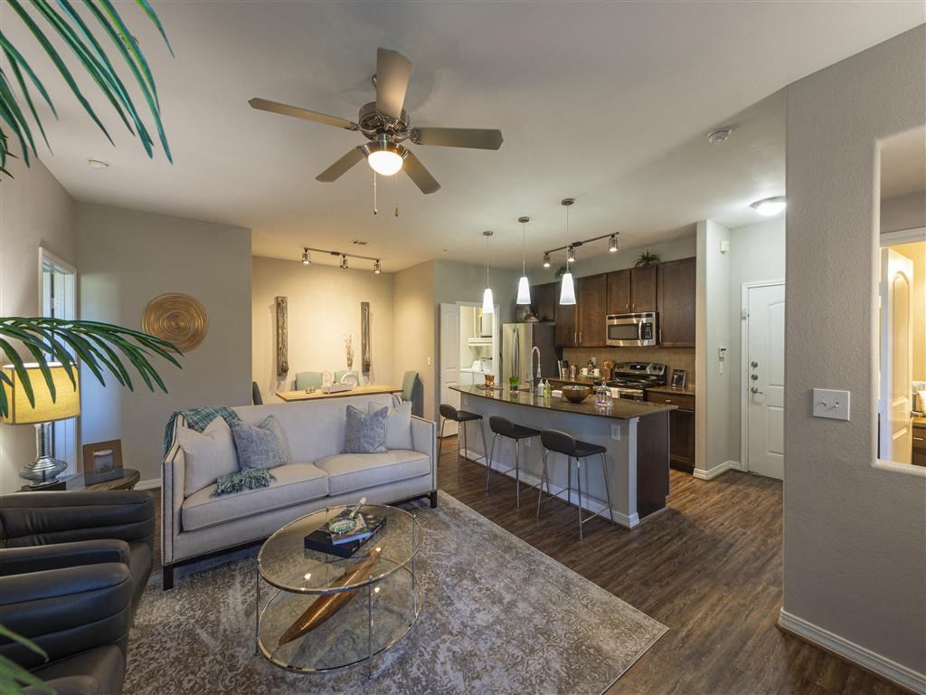 a living room and kitchen with a ceiling fan