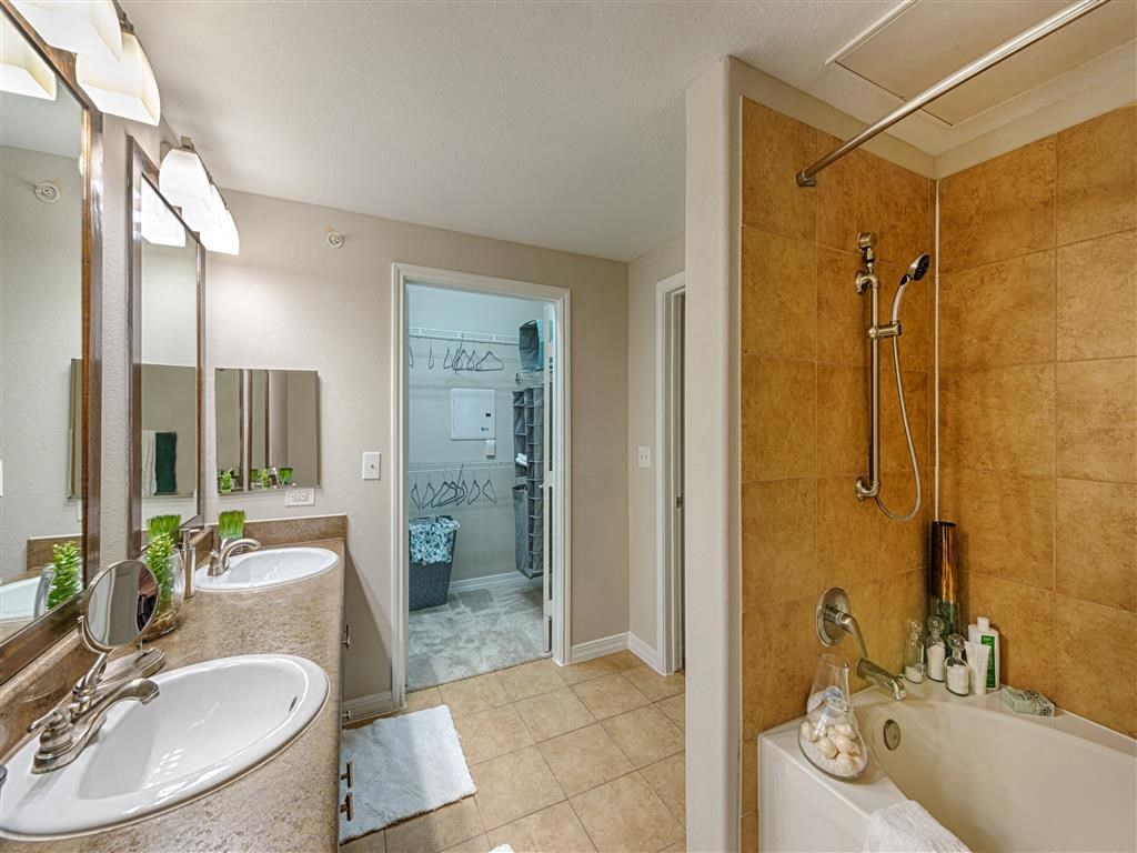 a bathroom with a tub and a shower and a sink