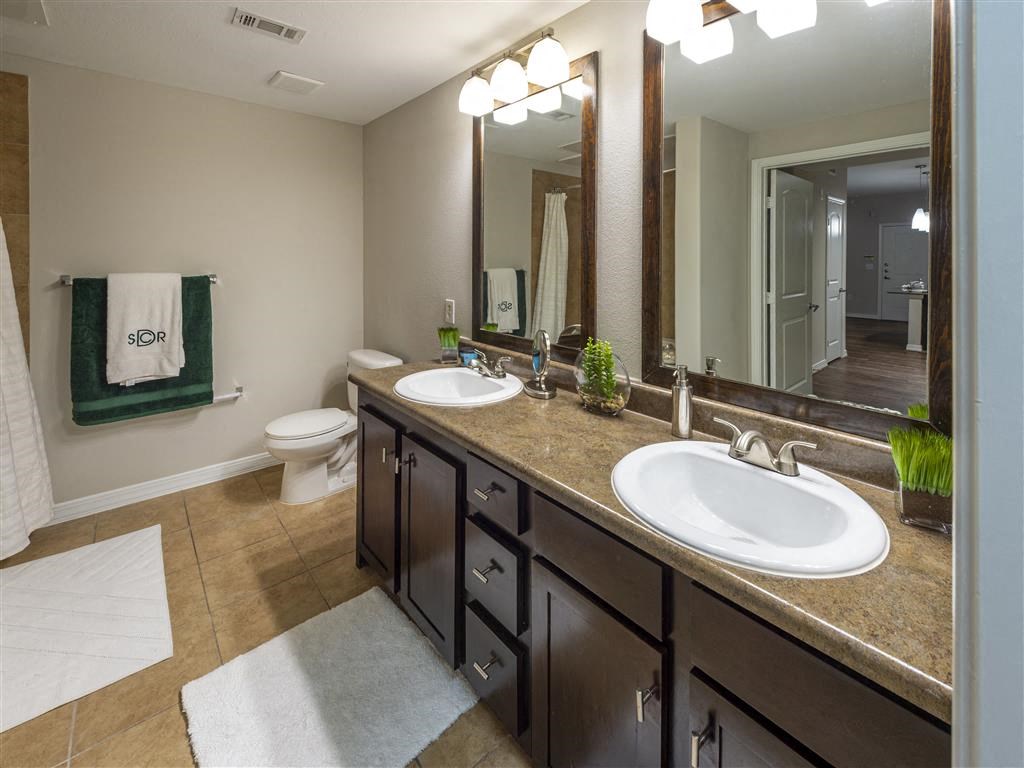 a bathroom with two sinks and a toilet