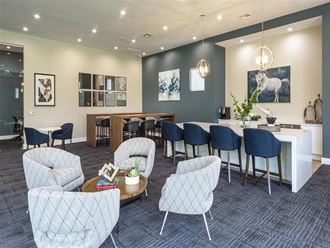 a lounge area with chairs and tables and a bar