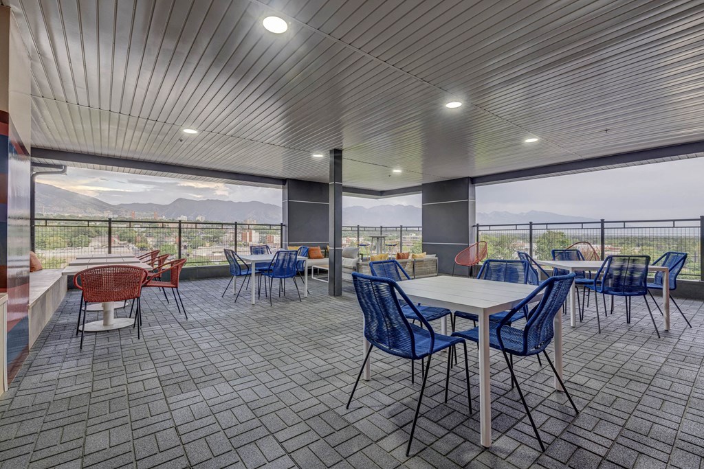 a cafeteria with tables and chairs and a view of mountains