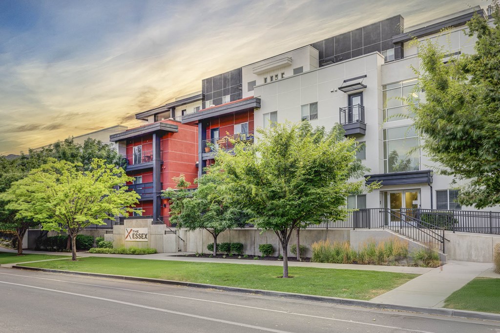 an apartment building on a city street with trees