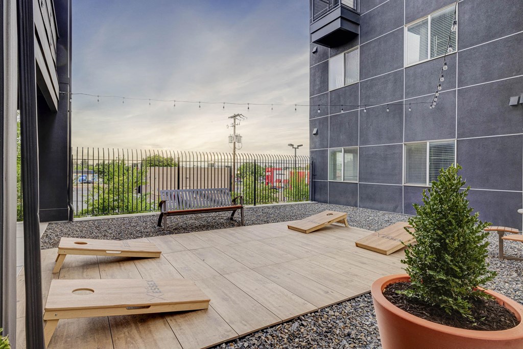 a patio with benches and a tree in front of a building