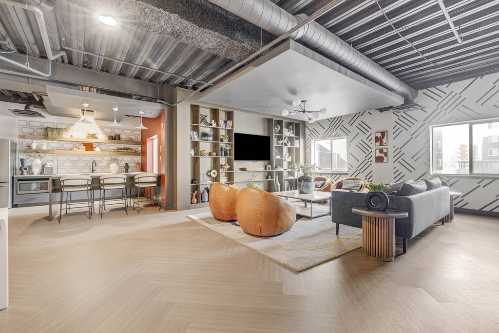 a living room with a couch and a table and a kitchen in the background