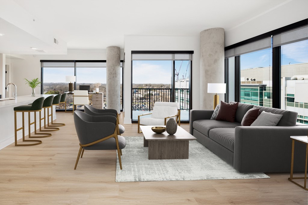a living room with a gray couch and a coffee table   and a balcony