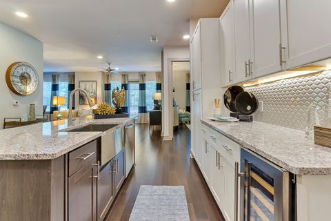 A modern kitchen with a marble countertop and stainless steel appliances.