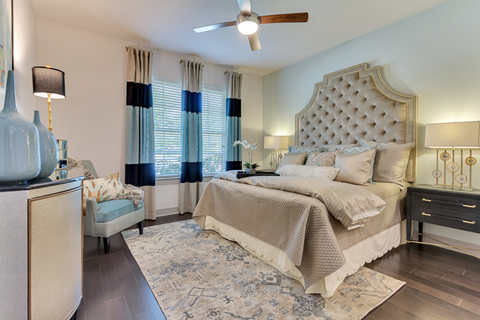 A bedroom with a large bed and a ceiling fan.