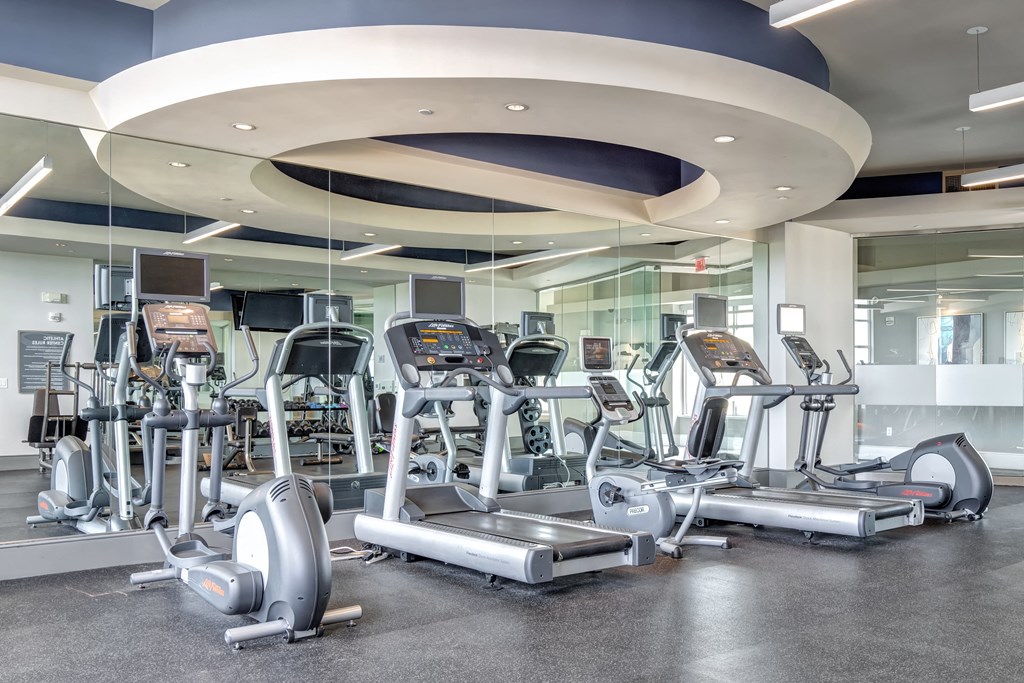a room filled with cardio equipment and weights