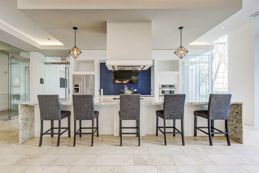 a large kitchen with a large island with bar stools and a blue accent wall