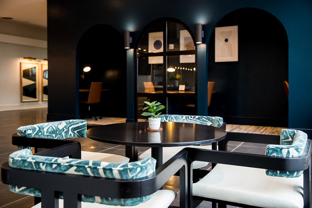 a room with blue chairs and a black table with a plant in the middle of it