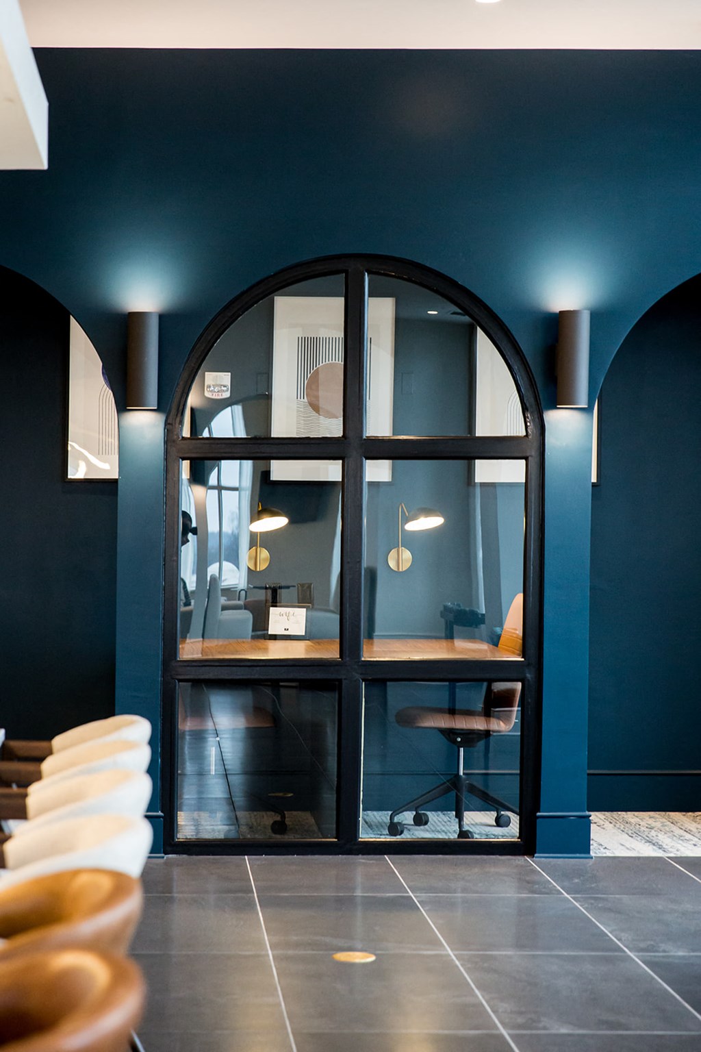 a blue office with a large window and a desk with a chair in front of it