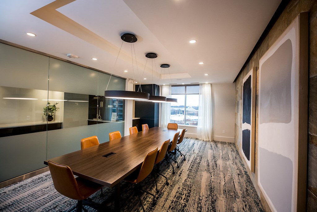 a meeting room with a long wooden table and yellow chairs