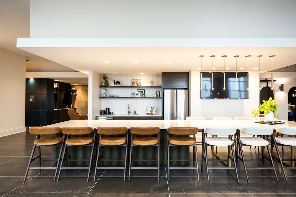 a kitchen with white walls and a large island with a long white countertop