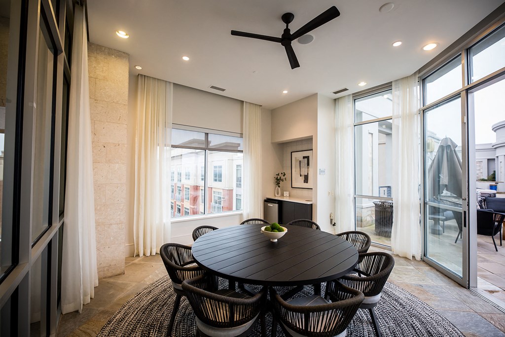 a dining area with a black dining table and black chairs
